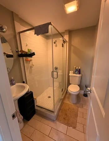 a bathroom with a sink a toilet and shower