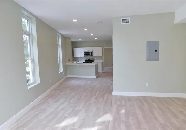 a view of a kitchen with a sink and dishwasher a refrigerator with wooden floor