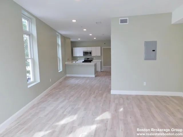 a view of a kitchen with cabinets stainless steel appliances wooden floor and a window