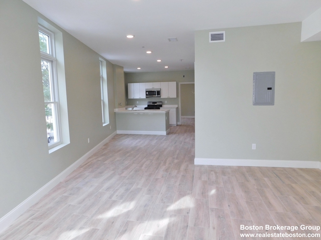 10 Roxbury Street, Unit 3 Boston, MA 02119 - Photo 3 of 11 a view of a kitchen with cabinets stainless steel appliances wooden floor and a window