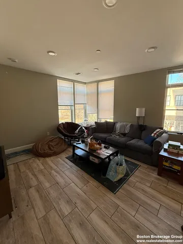 a living room with furniture hard wood floor and window