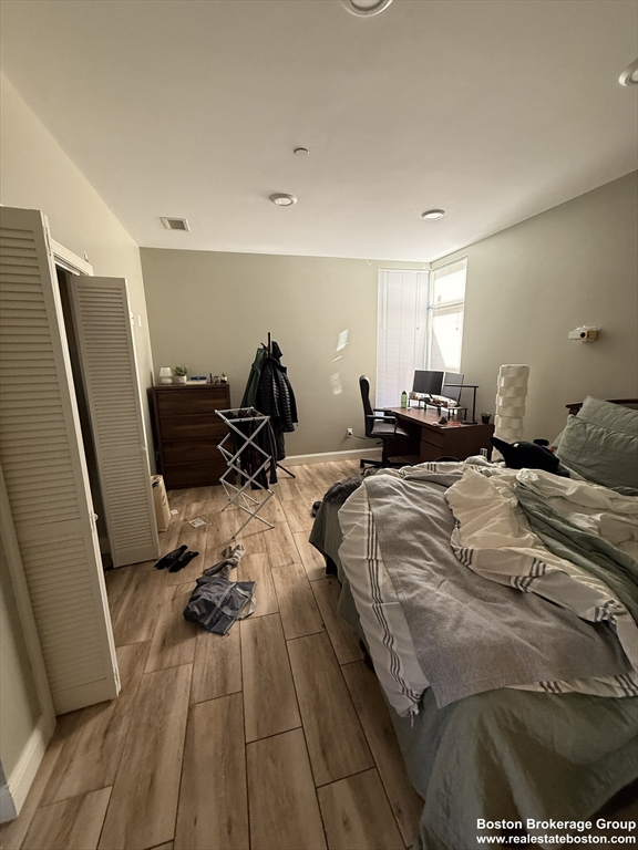 10 Roxbury Street, Unit 3 Boston, MA 02119 - Photo 8 of 11 a bed room with a bed furniture and a wooden floor