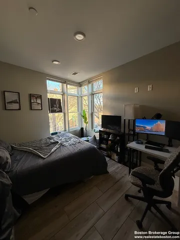 a bedroom with a bed a couch and large window