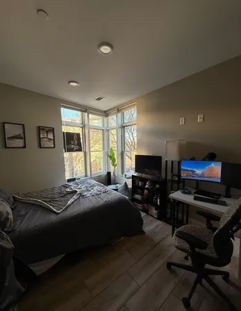 a bedroom with a bed and wooden floor