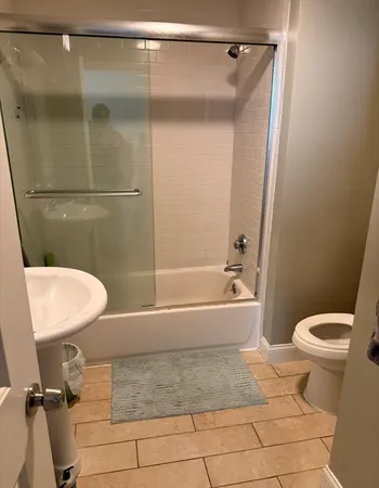 a bathroom with a granite countertop bathtub shower and toilet