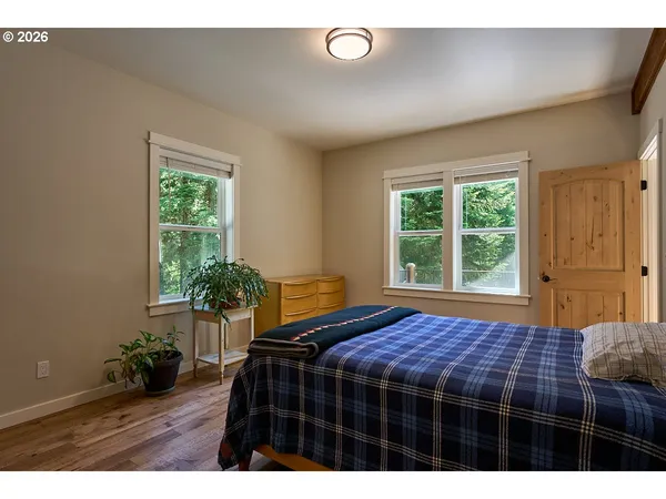 a bedroom with a bed window and wooden floor