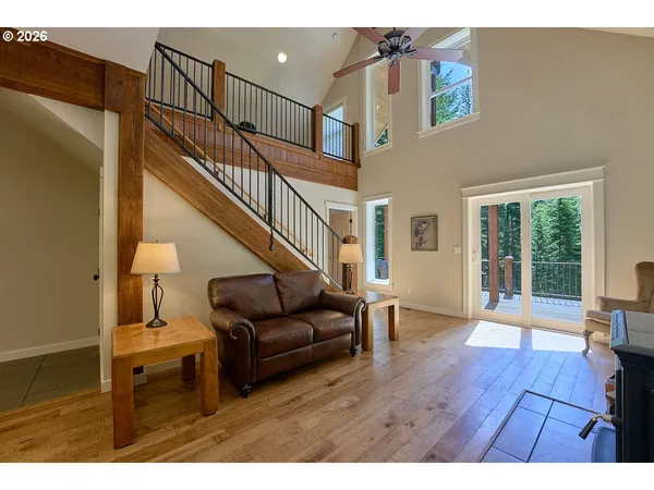 a living room with couches and a dining table with wooden floor