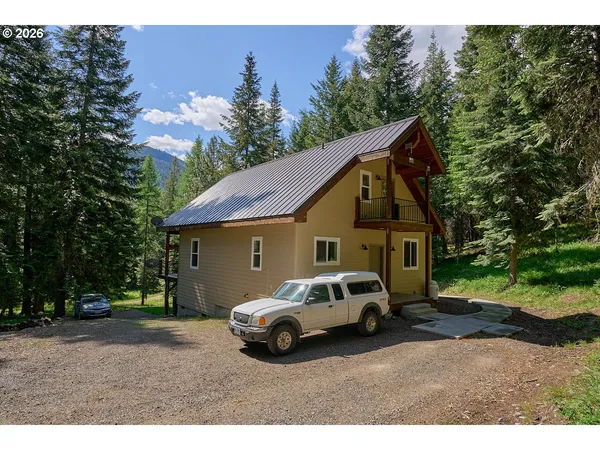a view of a white house and a car parked in front of it
