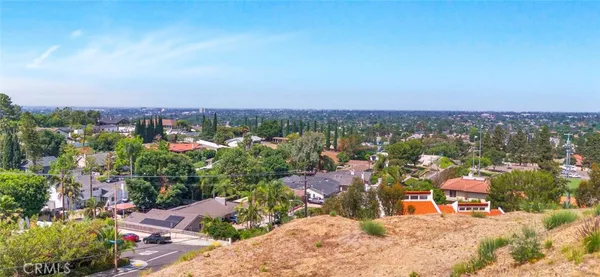 an aerial view of a house with a yard and mountain view in back