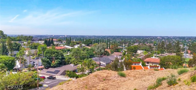 an aerial view of a house with a yard and mountain view in back