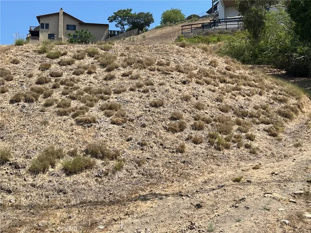 a view of a dry yard covered with snow in the background