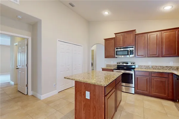 a kitchen with stainless steel appliances granite countertop a stove top oven a sink and dishwasher