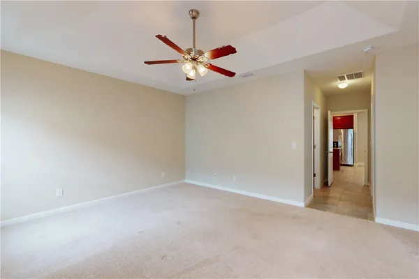 an empty room with closet and a ceiling fan