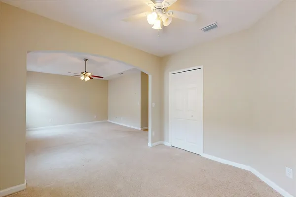 an empty room with a ceiling fan and a window