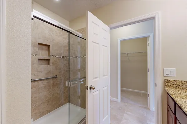 a bathroom with a granite countertop shower and a sink