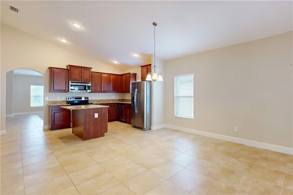 a kitchen with stainless steel appliances granite countertop a stove a sink a refrigerator and a microwave