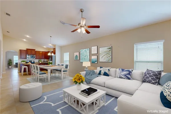 a living room with furniture kitchen view and a window
