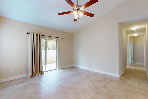 an empty room with closet and a chandelier fan