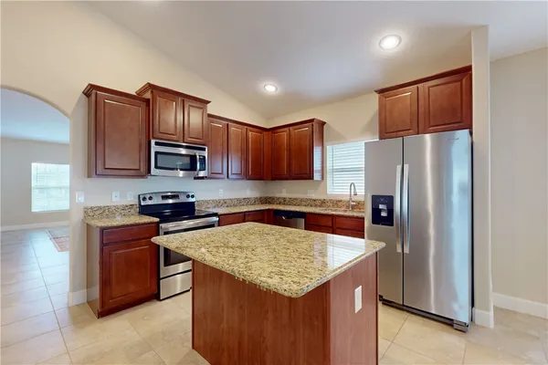 a kitchen with stainless steel appliances granite countertop a refrigerator stove microwave sink and cabinets