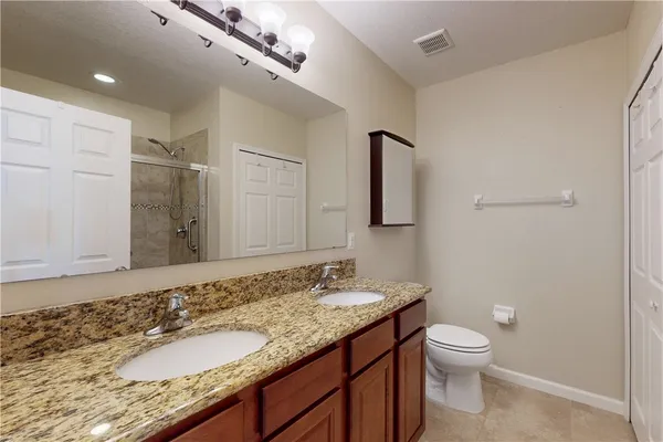 a bathroom with a granite countertop sink toilet and shower