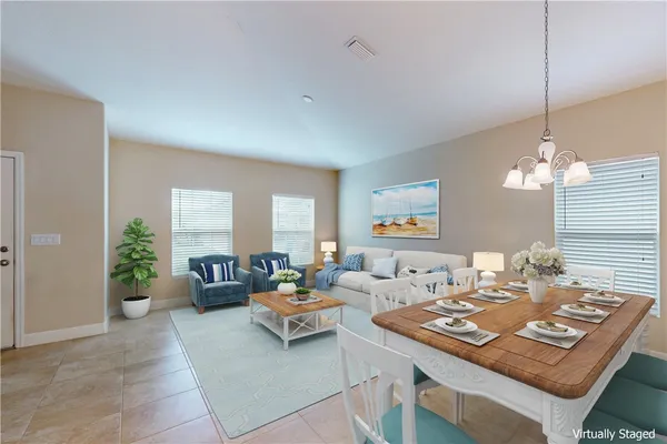 a living room with furniture a chandelier and a table