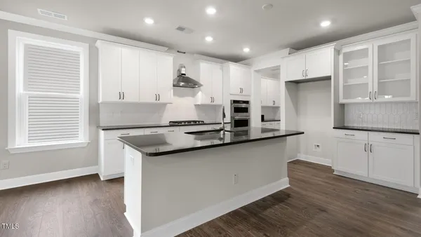 a kitchen with stainless steel appliances granite countertop a sink stove and cabinets