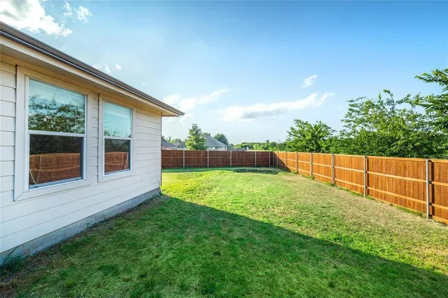 a view of yard with swimming pool and wooden fence