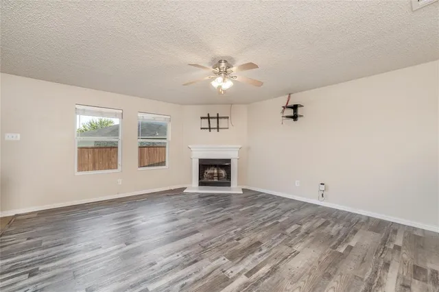a view of an empty room with a fireplace and a window