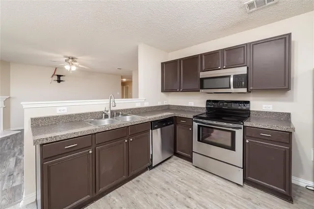 a kitchen with stainless steel appliances granite countertop a sink and stove top oven