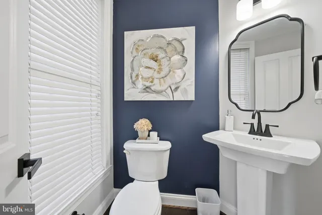 a bathroom with a toilet a sink and mirror