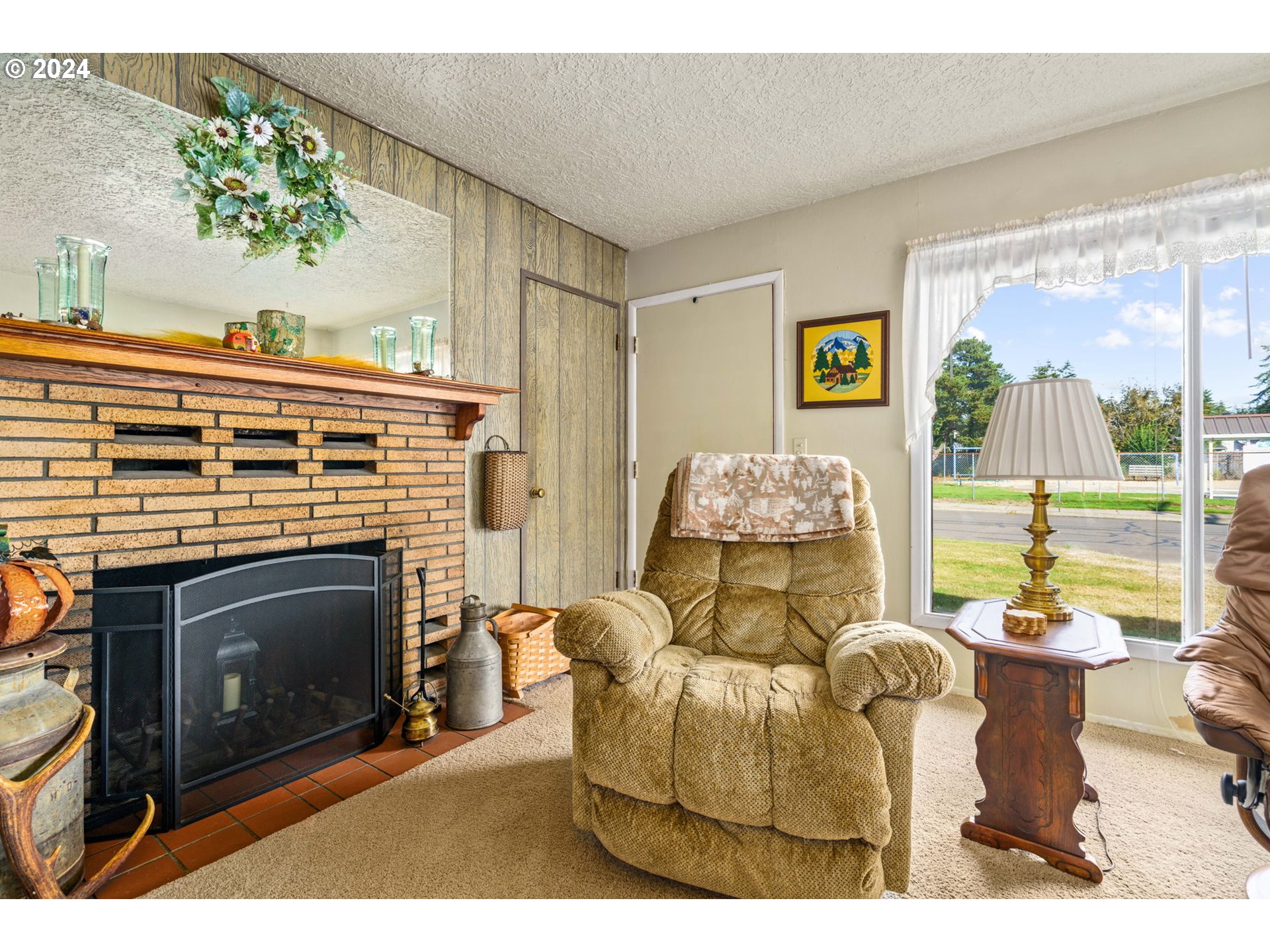 2290 18th Street Florence, OR 97439 - Photo 6 of 32 a living room with furniture a flat screen tv and a fireplace