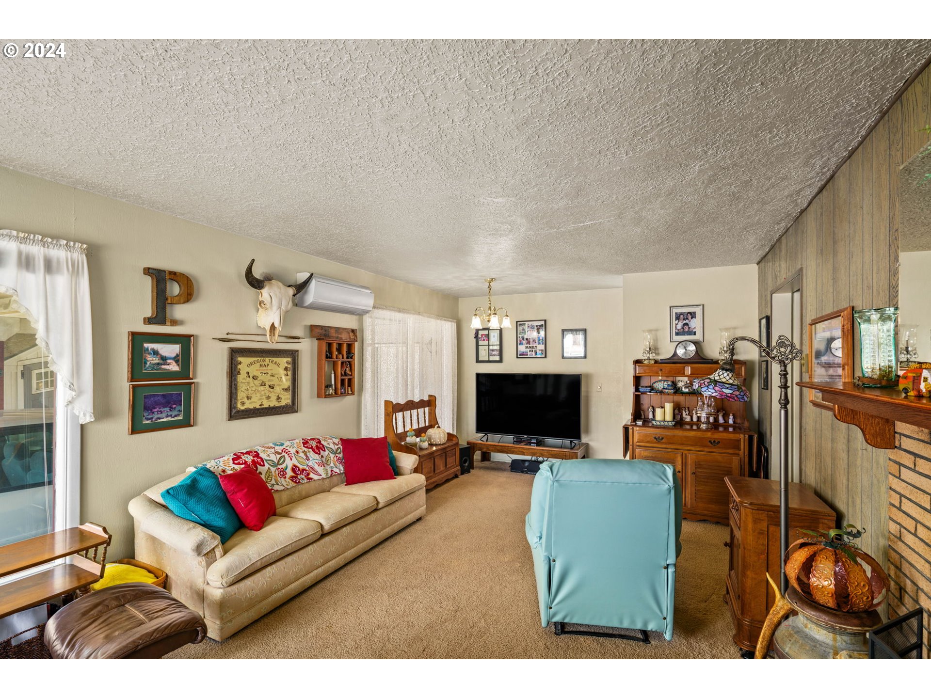 2290 18th Street Florence, OR 97439 - Photo 8 of 32 a living room with furniture a flat screen tv and a wall painting