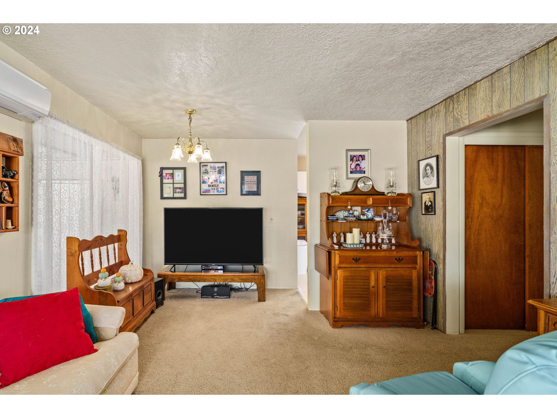 2290 18th Street Florence, OR 97439 - Photo 9 of 32 a living room with furniture a flat screen tv and a refrigerator