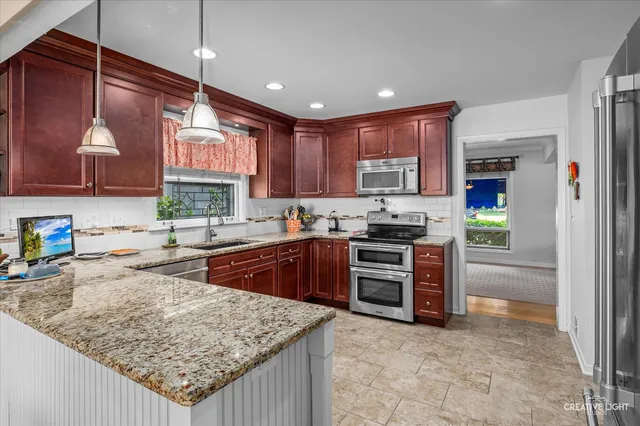 a kitchen with stainless steel appliances granite countertop a stove oven and a refrigerator