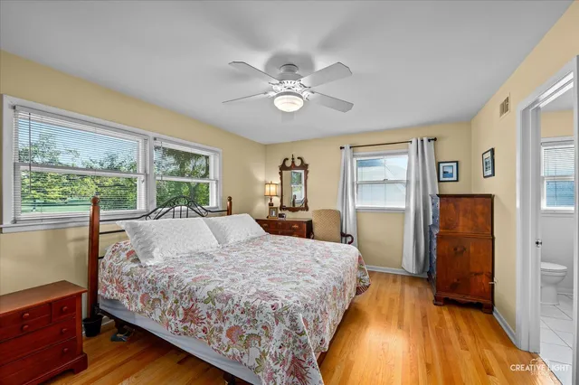a bed sitting in a spacious bedroom next to a window