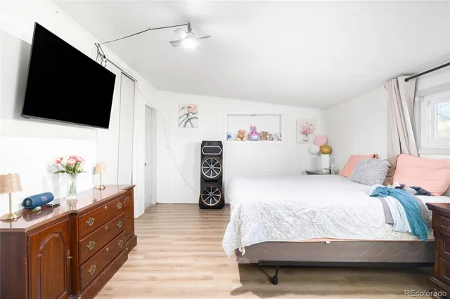 a bedroom with a bed and a flat tv screen on dresser