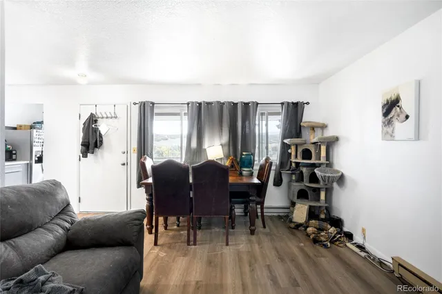 a living room with furniture a desk and chair with wooden floor