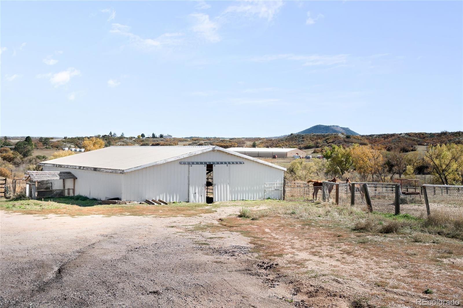 5354 Jackson Creek Road Sedalia, CO 80135 - Photo 40 of 47 a view of a house with a yard and large tree