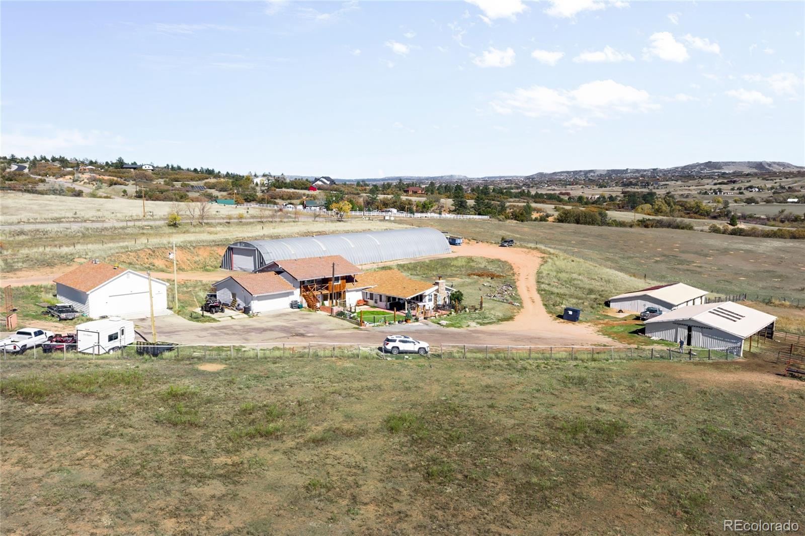 5354 Jackson Creek Road Sedalia, CO 80135 - Photo 43 of 47 a view of a lake with lawn chairs and large trees