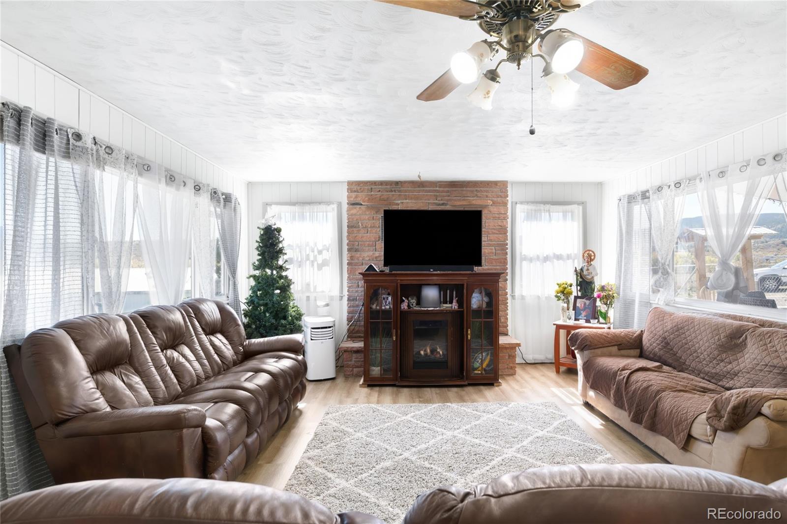 5354 Jackson Creek Road Sedalia, CO 80135 - Photo 10 of 47 a living room with furniture and a flat screen tv