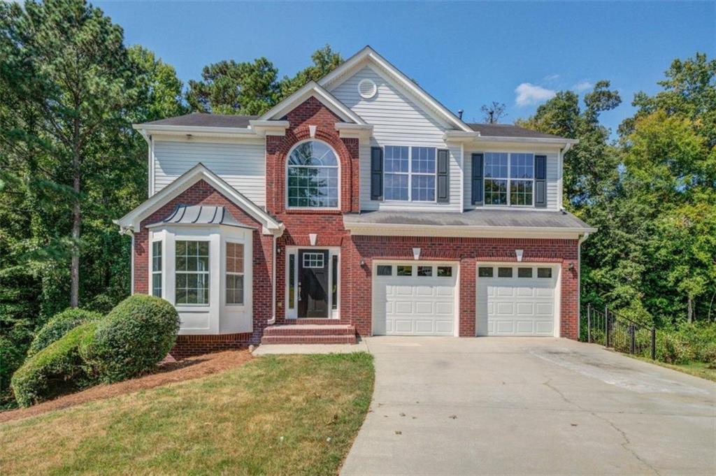 a front view of a house with a yard and garage