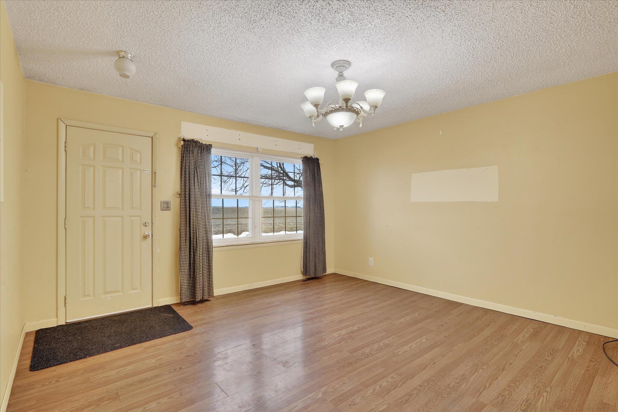 219 River Road Rochelle, IL 61068 - Photo 13 of 40 an empty room with wooden floor and windows