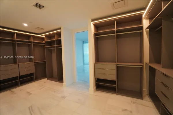 a view of walk in closet with empty racks