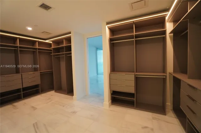 a view of walk in closet with empty racks