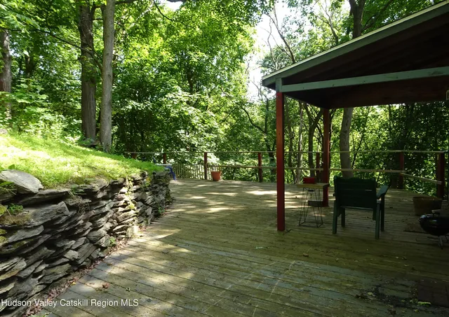 a backyard of a house with table and chairs under an umbrella
