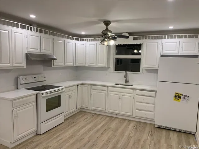 a kitchen with granite countertop a sink stainless steel appliances and cabinets