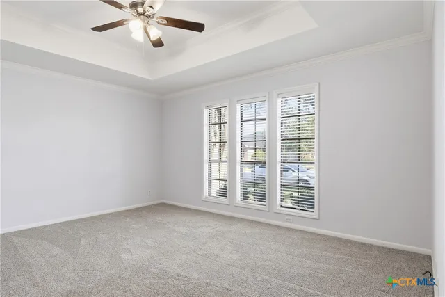 an empty room with chandelier fan