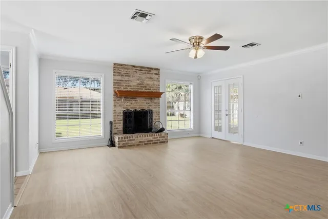 a view of an empty room with a window and fireplace