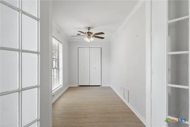 a view of a hallway with a ceiling fan