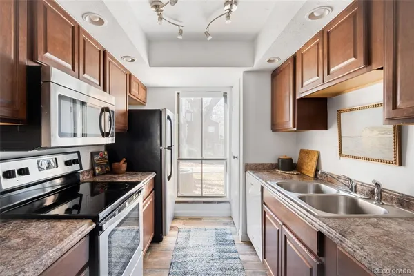a kitchen with stainless steel appliances granite countertop a sink stove and refrigerator